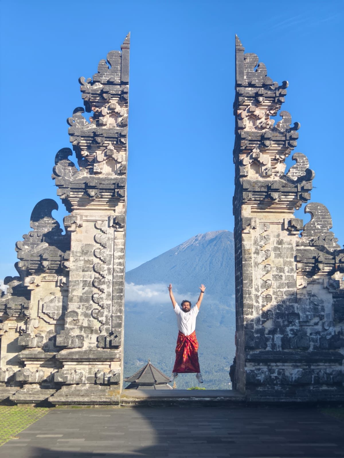 A guest at the Gate of Heaven with Mount Agung behind, Bali