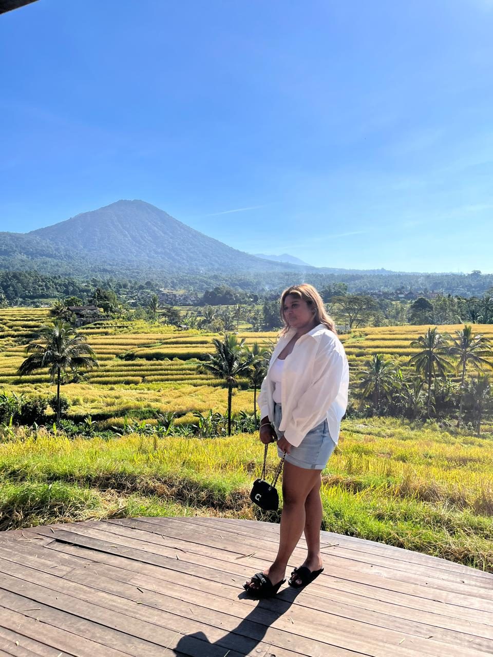 A traveler looking out over Bali rice fields and Mount Agung