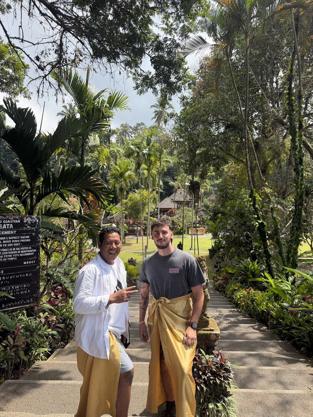 Guests with their driver in sarongs at a Balinese temple entrance